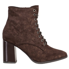 Kylie Botas amarradas em um poste marrom