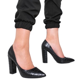 Sapatos pretos em um poste com um padrão de pele de cobra Desta forma Sapatos pretos em um poste com um padrão de pele de cobra Desta forma