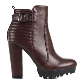 Botas marrons em um poste alto de manga clarete vermelho