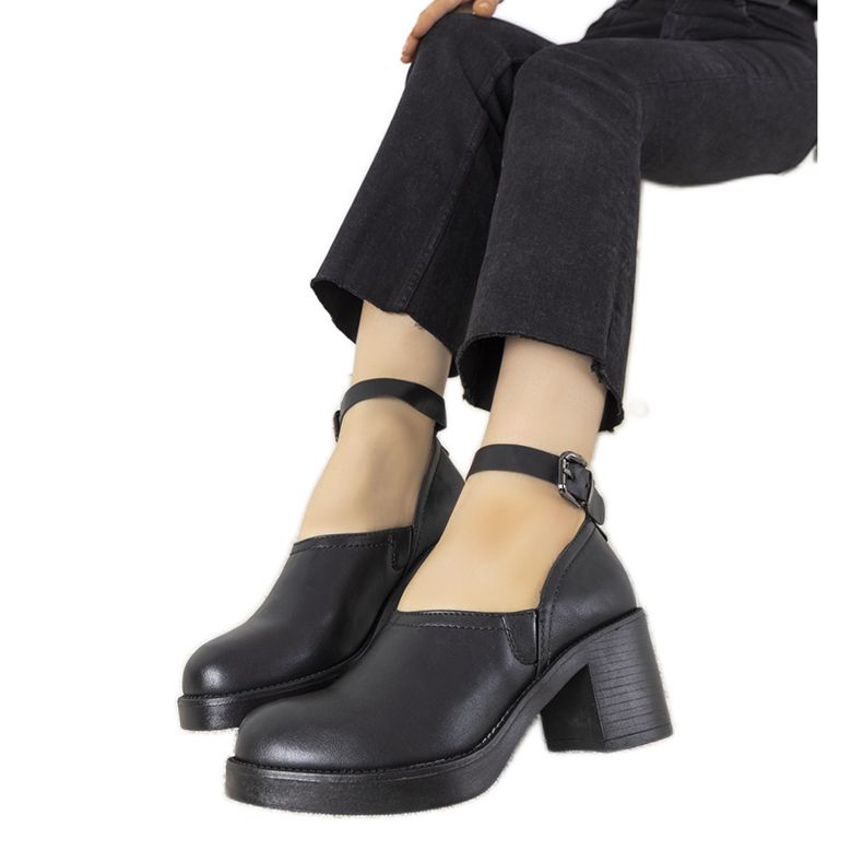 Sapatos pretos no posto de Christiane