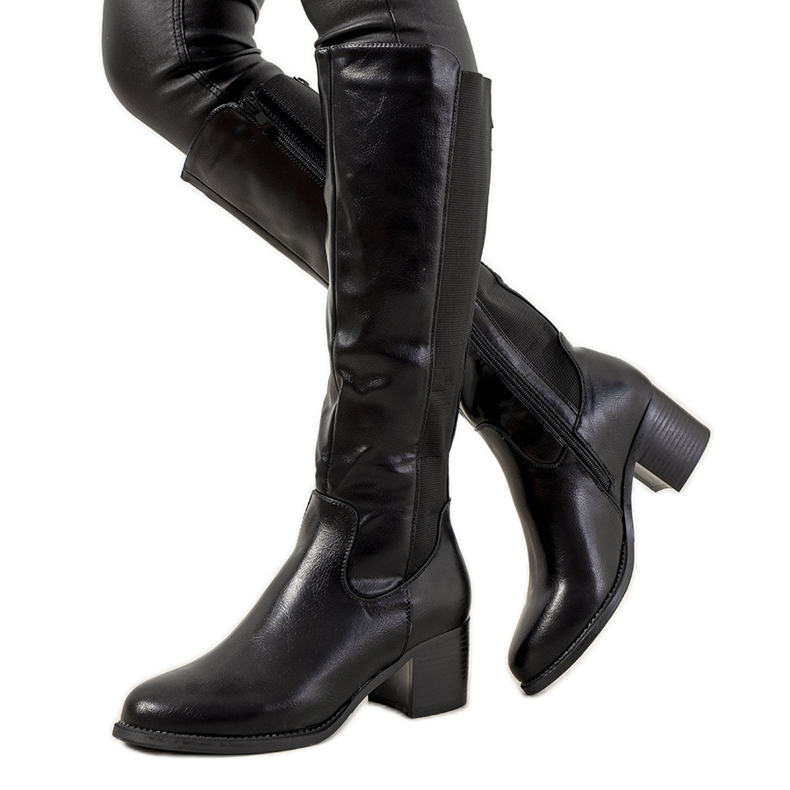 Botas pretas no poste isolado de Jurado preto Botas pretas no poste isolado de Jurado preto