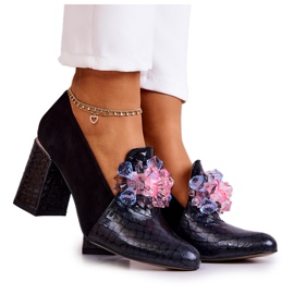 Sapatos de pele de cobra de camurça em um suporte de sofá preto