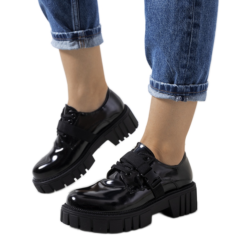 Sapatos pretos em uma sola de trator por Vellem