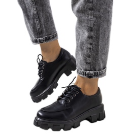 Sapatos pretos em uma sola de trator felina Sapatos pretos em uma sola de trator felina