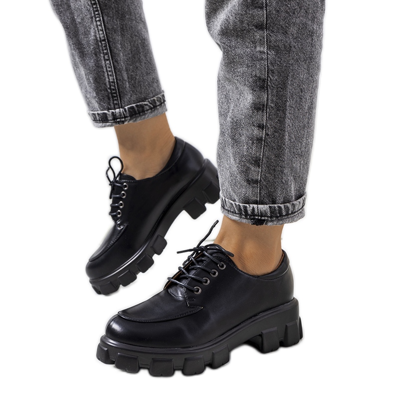 Sapatos pretos em uma sola de trator felina Sapatos pretos em uma sola de trator felina