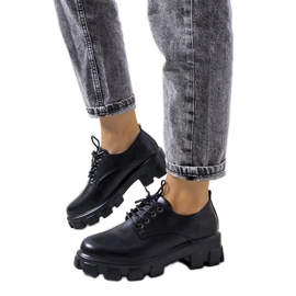 Sapatos pretos em uma sola de trator Chedi