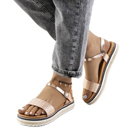 Sandálias douradas em uma plataforma ornamentada de Acton dourado