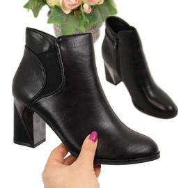 Jezzi Botas isoladas pretas em um poste decorativo preto Jezzi Botas isoladas pretas em um poste decorativo preto