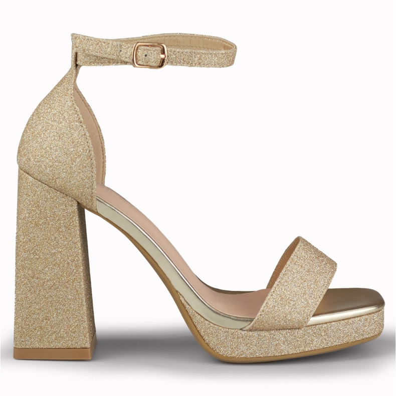 Sandálias brilhantes de ouro em um salto alto largo dourado