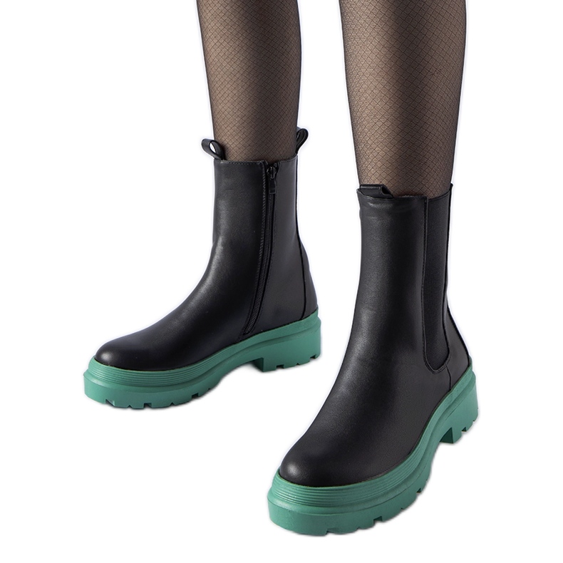 Botas pretas em uma sola verde preto