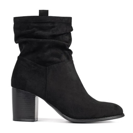 Botas femininas de camurça preta no poste preto