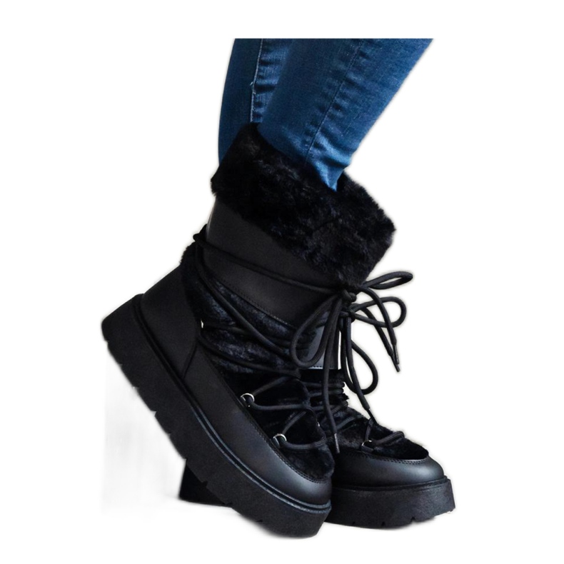 Botas de neve pretas isoladas com cordões e decoradas com pele preto