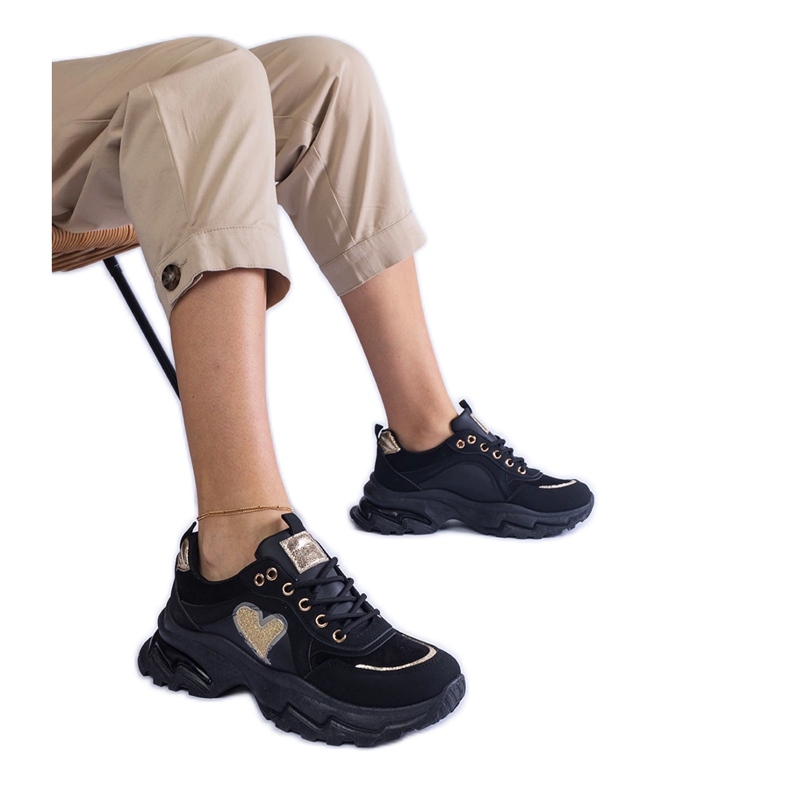 Tênis pretos em uma plataforma de coração preto