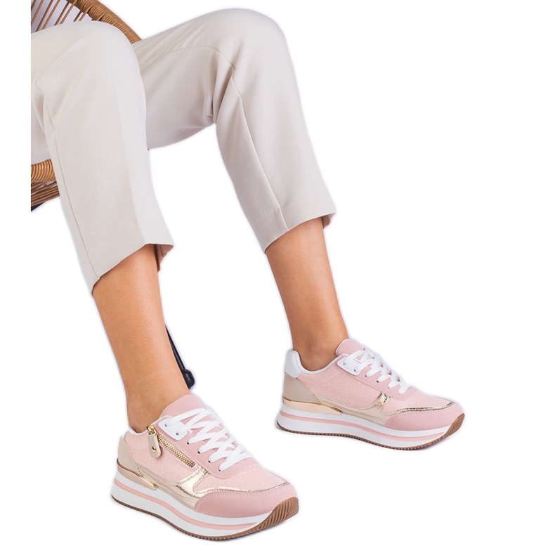 Tênis esportivos rosa na plataforma com uma inserção dourada