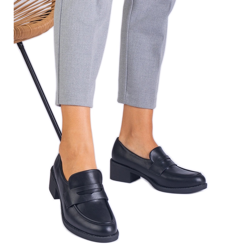 Bombas Eco -Leather pretas em um post baixo preto