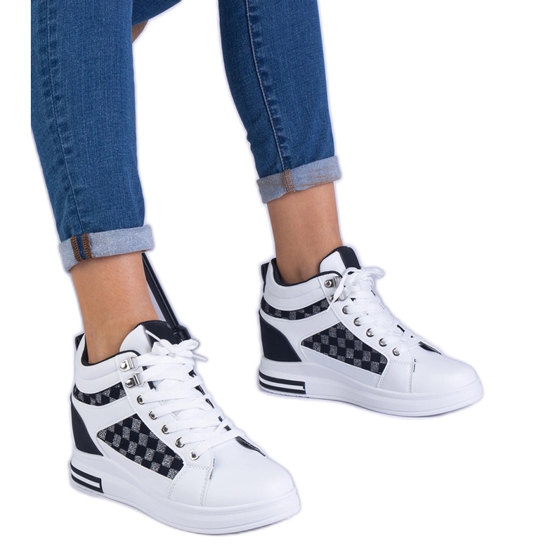 Tênis brancos femininos em uma cunha escondida preto