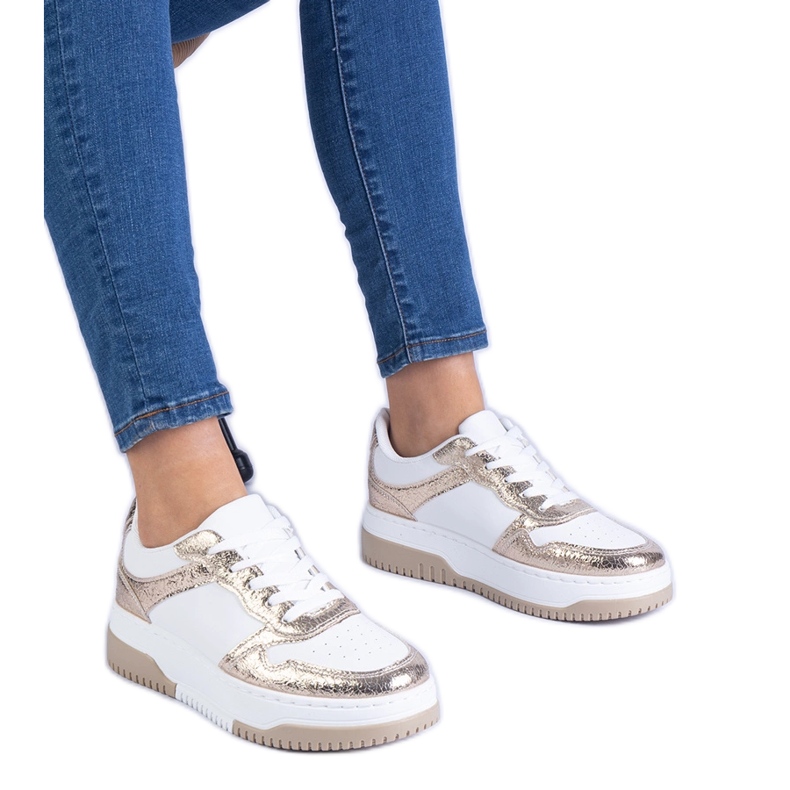 Tênis dourados em uma sola grossa