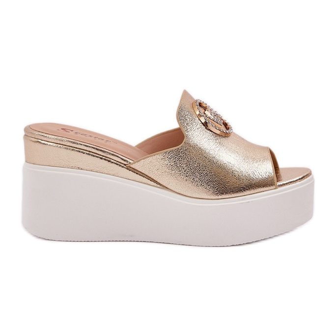 Slippers na plataforma e cunhas com um ornamento dourado