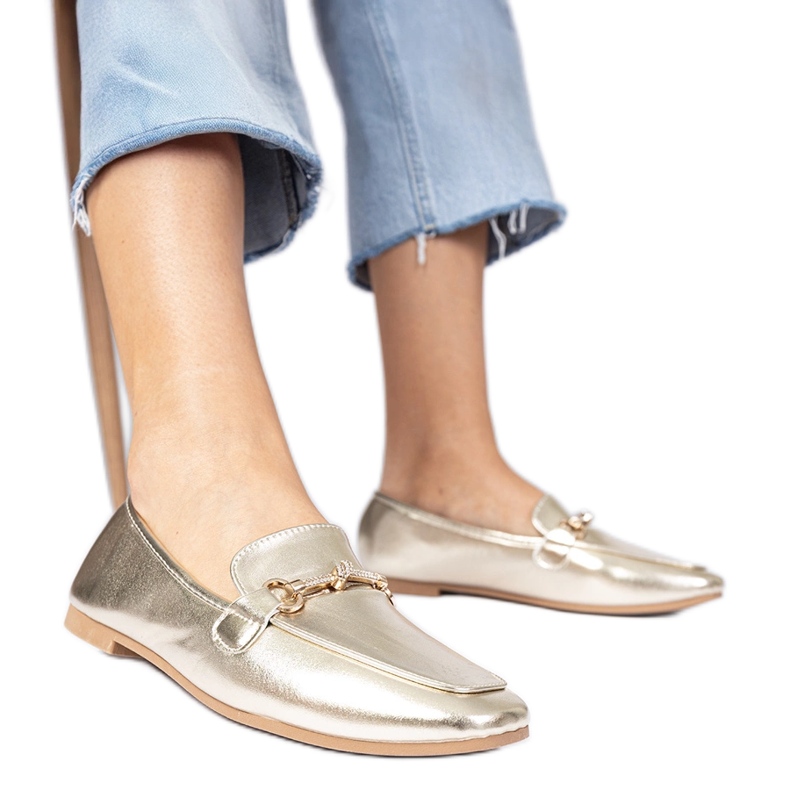 Mocas elegantes de ouro com uma decoração de ouro e zircões dourado