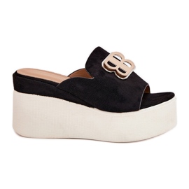 Slippers na plataforma e cunhas com uma decoração preta preto