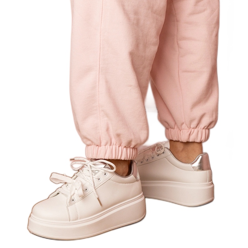 Tênis de esportes brancos e prateados na plataforma