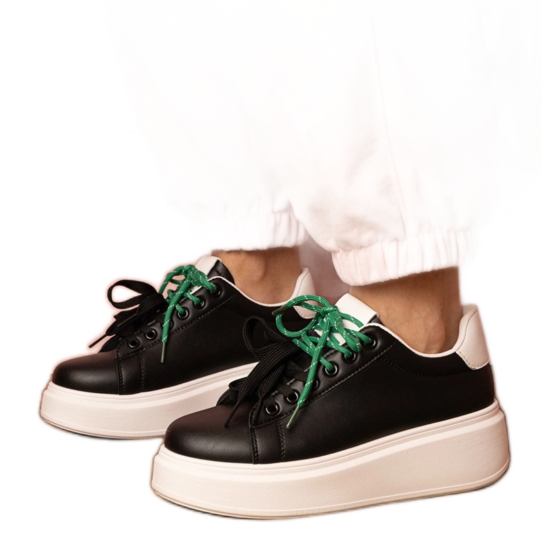 Tênis esportivos negros na plataforma preto