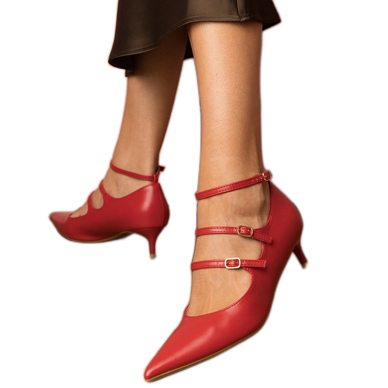 Bombas vermelhas em uma pilha baixa com fivelas vermelho Bombas vermelhas em uma pilha baixa com fivelas vermelho