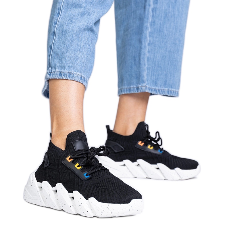 Tênis esportivos negros em uma sola enorme preto