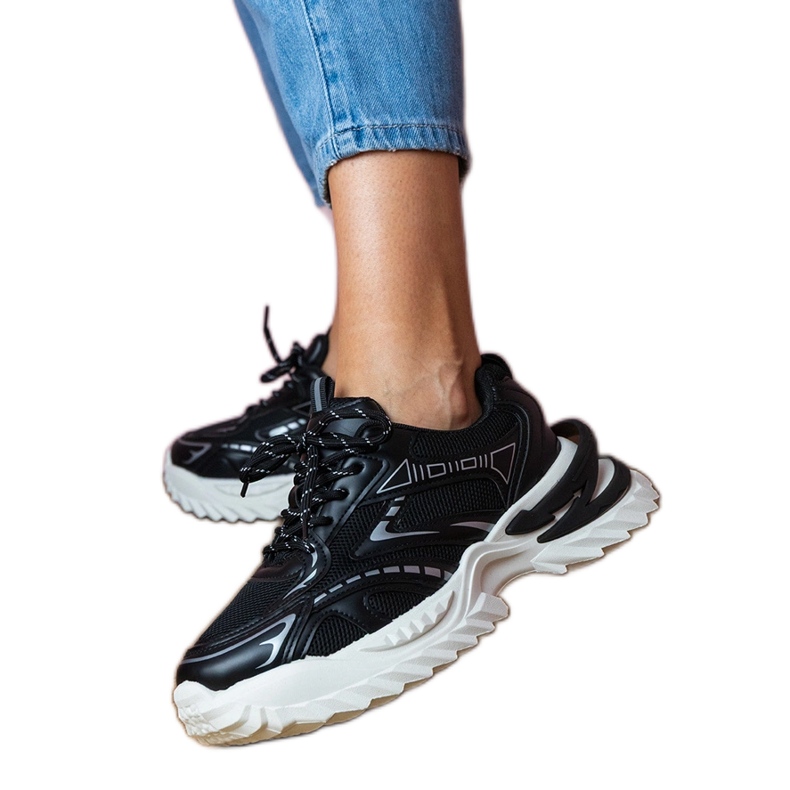 Tênis de esportes negros em uma sola grossa preto