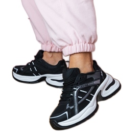 Tênis esportivos negros em uma sola enorme preto