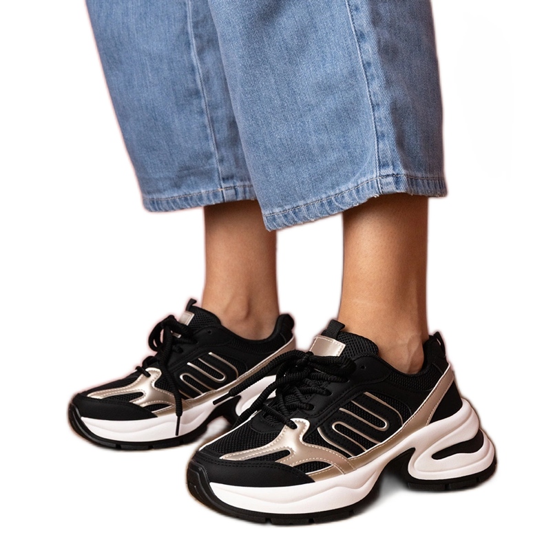 Tênis esportivos negros em uma sola enorme preto