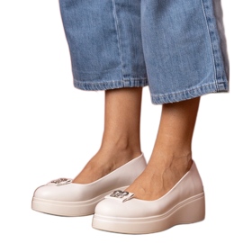 Sapatos brancos na plataforma com uma decoração de zircão