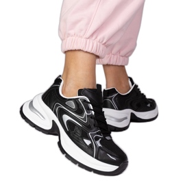 Tênis de esportes negros em uma sola grossa preto