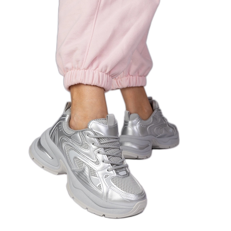 Tênis de esportes de prata em uma sola grossa