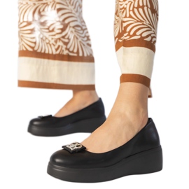 Sapatos pretos na plataforma com uma decoração de zircão