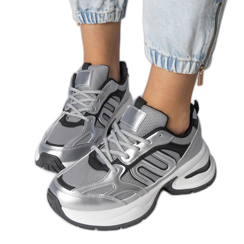 Tênis de esportes de prata em uma sola enorme