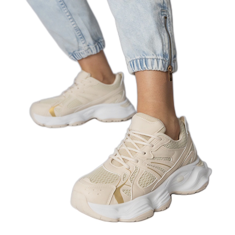 Tênis esportivos bege em uma sola enorme