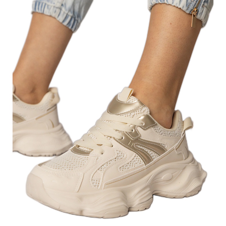 Esportes femininos de tênis bege com uma inserção dourada