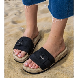 Flip -flops pretos na plataforma com uma fivela decorativa