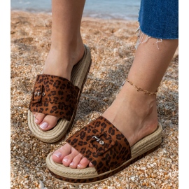 Flip -flops de leopardo na plataforma com uma fivela decorativa marrom