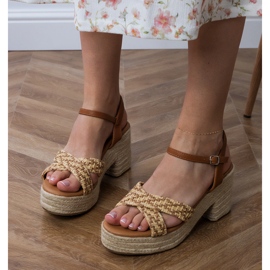 Sandálias marrons que se espalharam no poste castanho