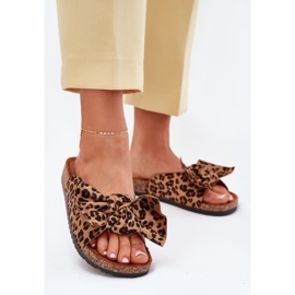 Chinelos femininos em uma sola de cortiça com uma tigela de arco marrom