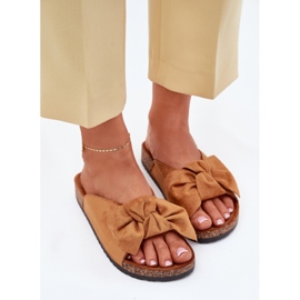 Chinelos femininos em uma sola de cortiça com um arco de camelo castanho