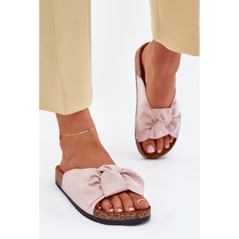 Chinelos femininos na sola de cortiça com um laço rosa claro