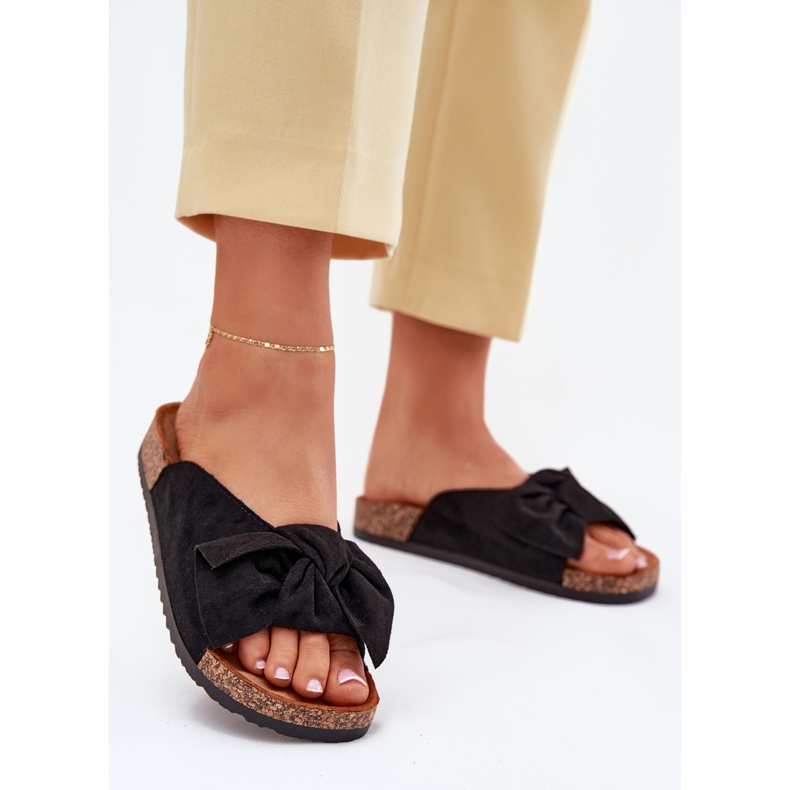 Chinelos femininos em uma sola de cortiça com um arco preto Chinelos femininos em uma sola de cortiça com um arco preto