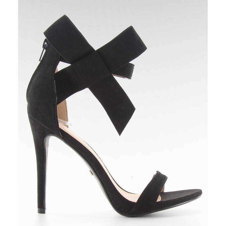 Sandálias pretas em um alfinete com um laço preto