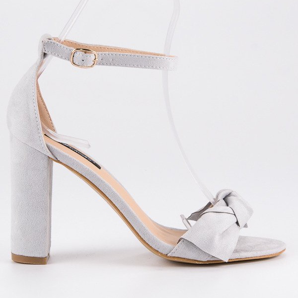 Sandálias de camurça em um poste cinza