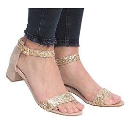 Sandálias douradas em um post em Montana dourado amarelo