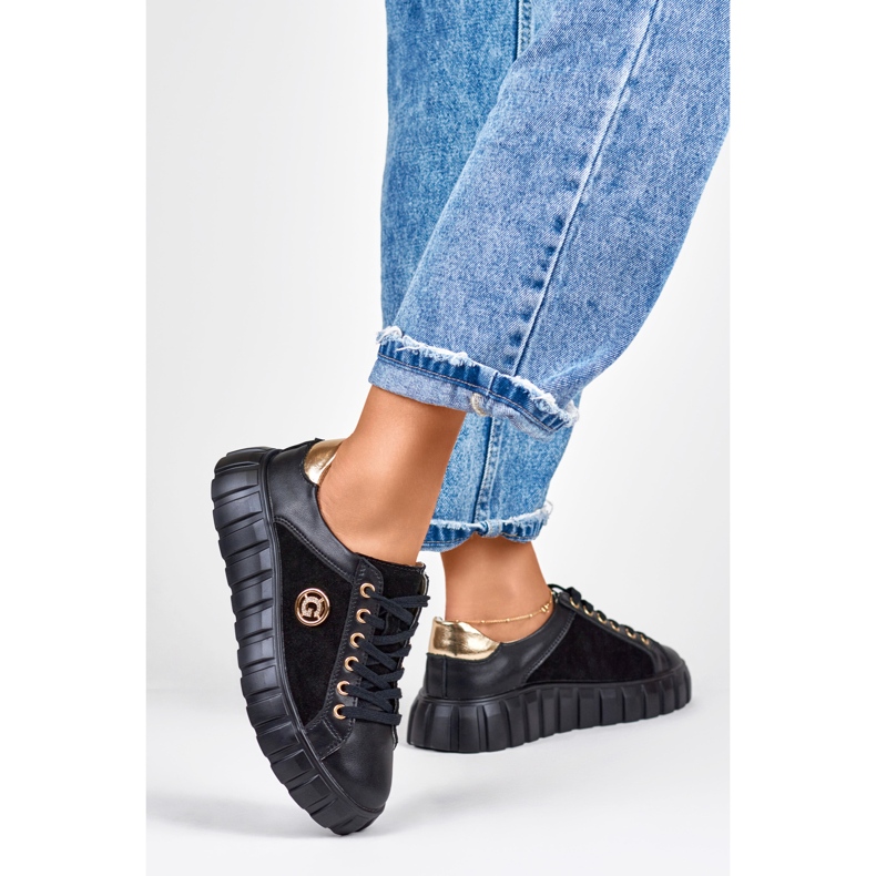 Tênis esportivo de couro preto com detalhes dourados 1