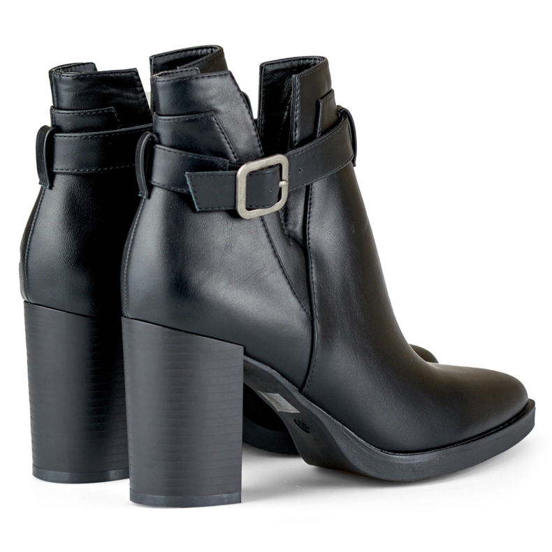 Botas pretas recortadas femininas em um poste bege 1